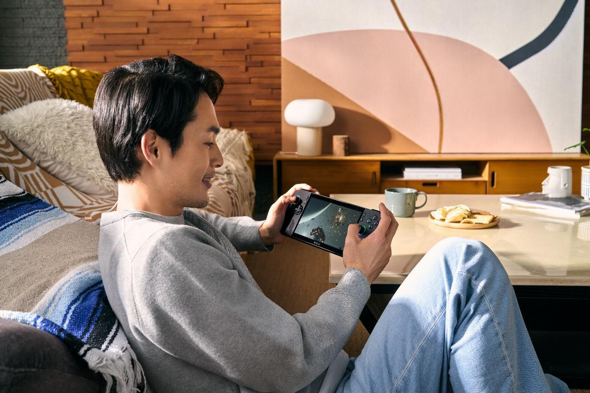 A person sitting on a couch holding a phoneDescription automatically generated A person sitting on a couch holding a phoneDescription automatically generated