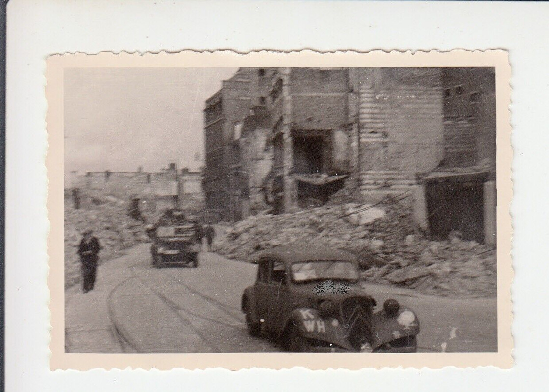 Deutsche Truppen mit PKW & LKW in zerstörter französischer Stadt