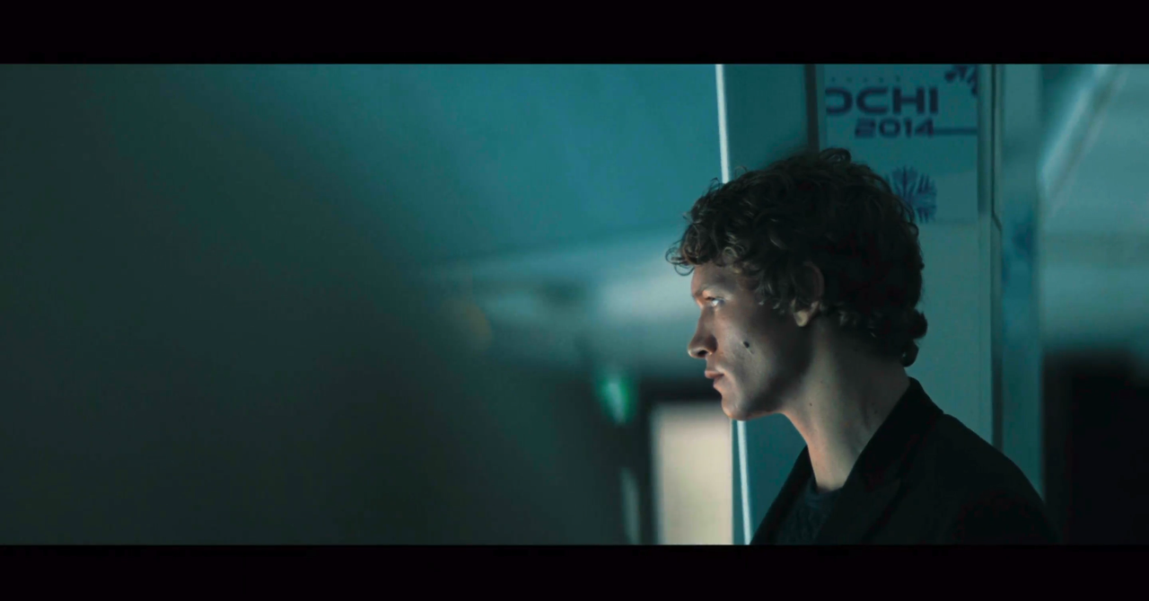the back of shane's shoulder fills the left half of the image. on the right side is ilya in profile.