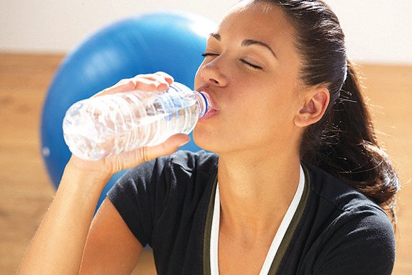 Devojka pije vodu iz plastične flaše