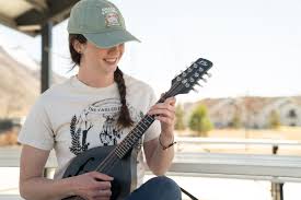 musician picking the paired strings of a mandolin