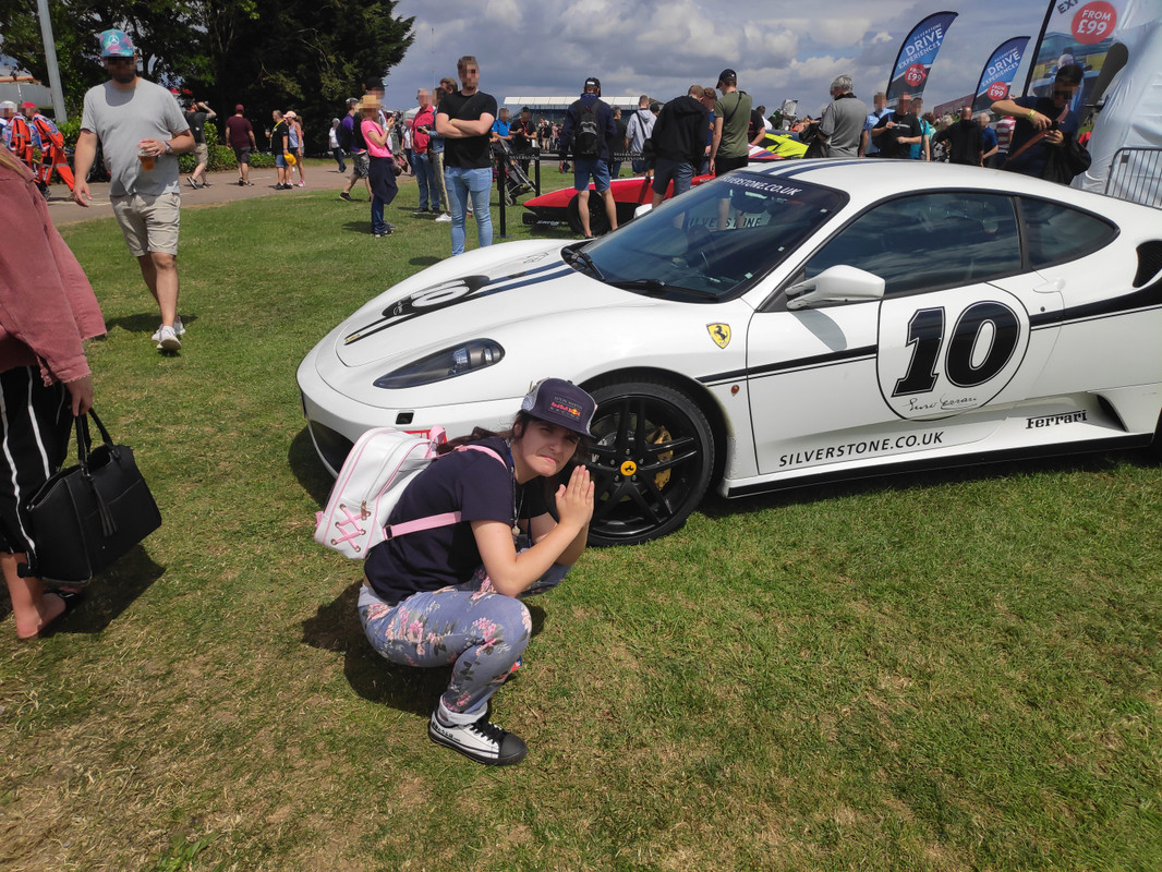 Hayley posing in front of a white sports car