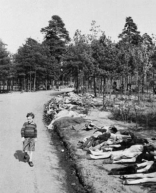 Un niño camina por una senda cubierta por cadáveres tras la liberación del campamento Bergen-Belsen, al norte de Alemania, en abril 1945