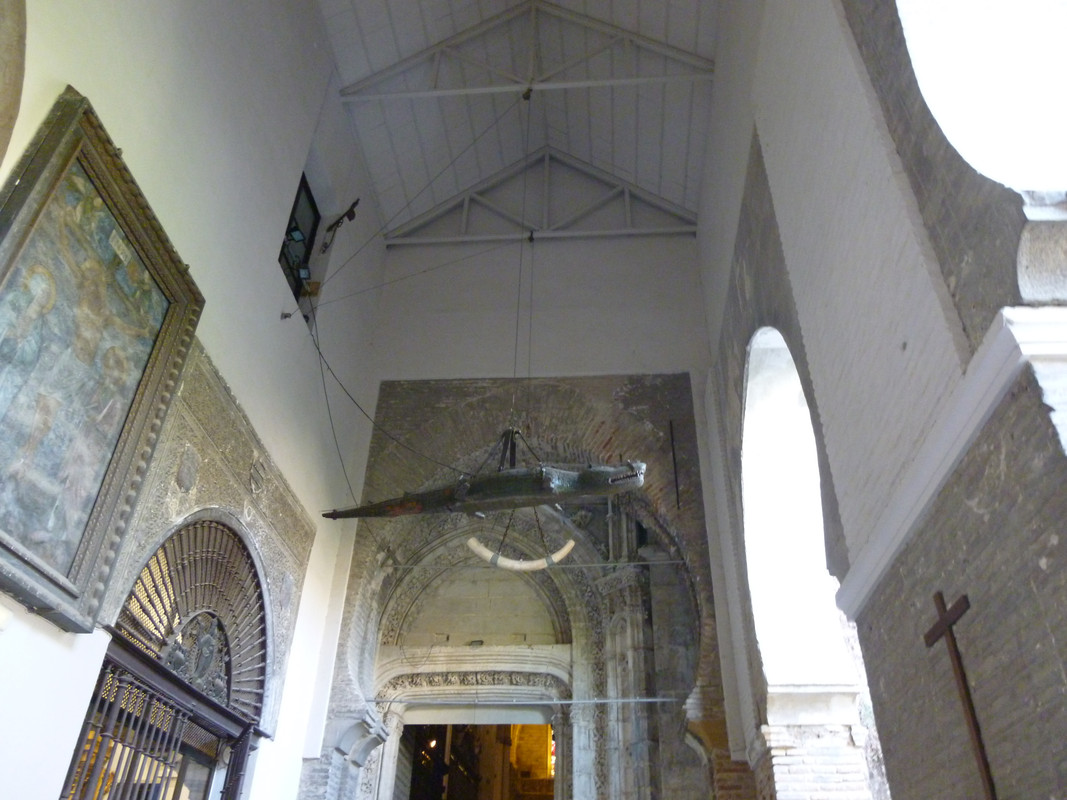 Wooden model of a crocodile, hanging from the ceiling by chains