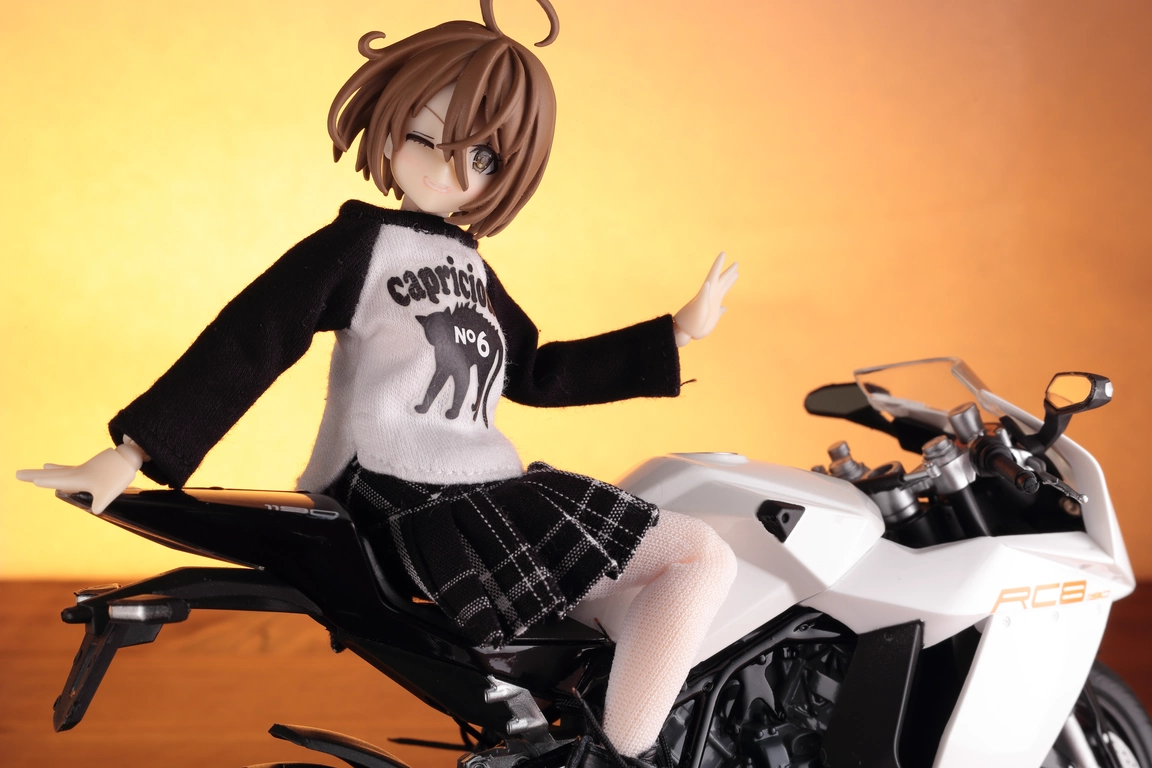 A right-side view of a 1:12 scale diecast model of the RC8 in white and “Assault Lily” Kawamura Yuzuriha wearing a 1/12 Kittycat Raglan T-shirt in black and white