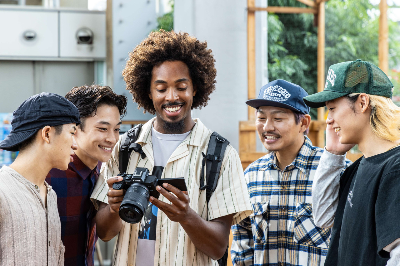Friends looking at photos together on the Canon EOS R8 Mark II's screen