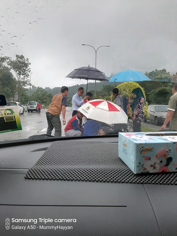 orang ramai payungkan mangsa kemalangan