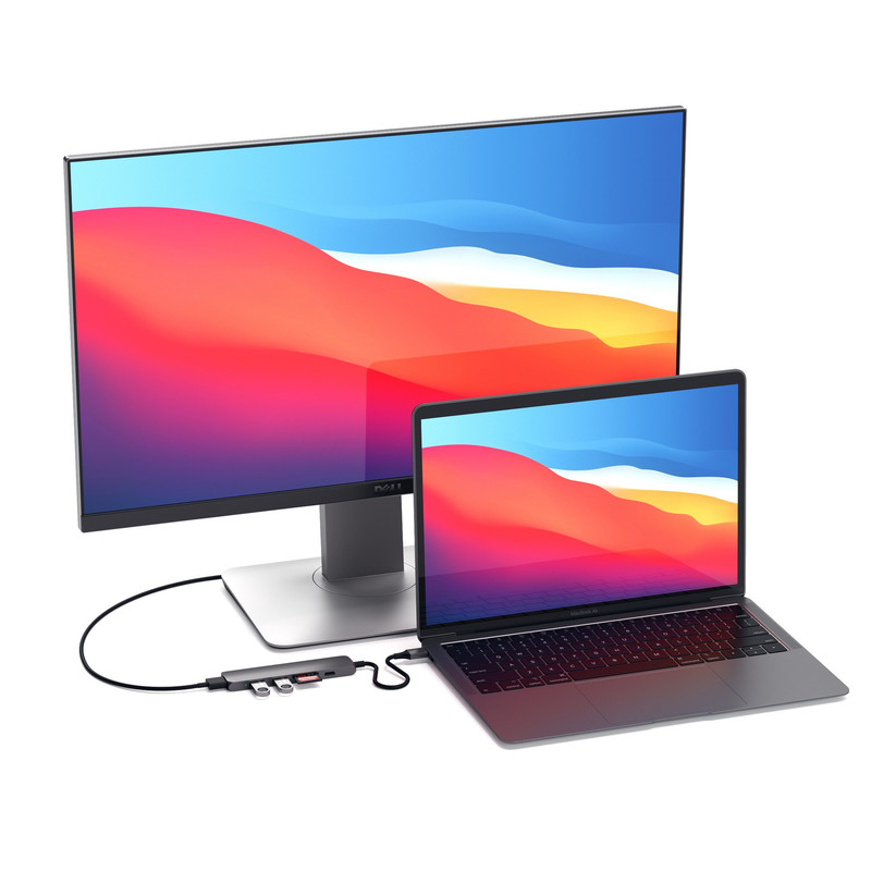 Adaptador Satechi Slim V2 conectado a una MacBook en un escritorio de trabajo.