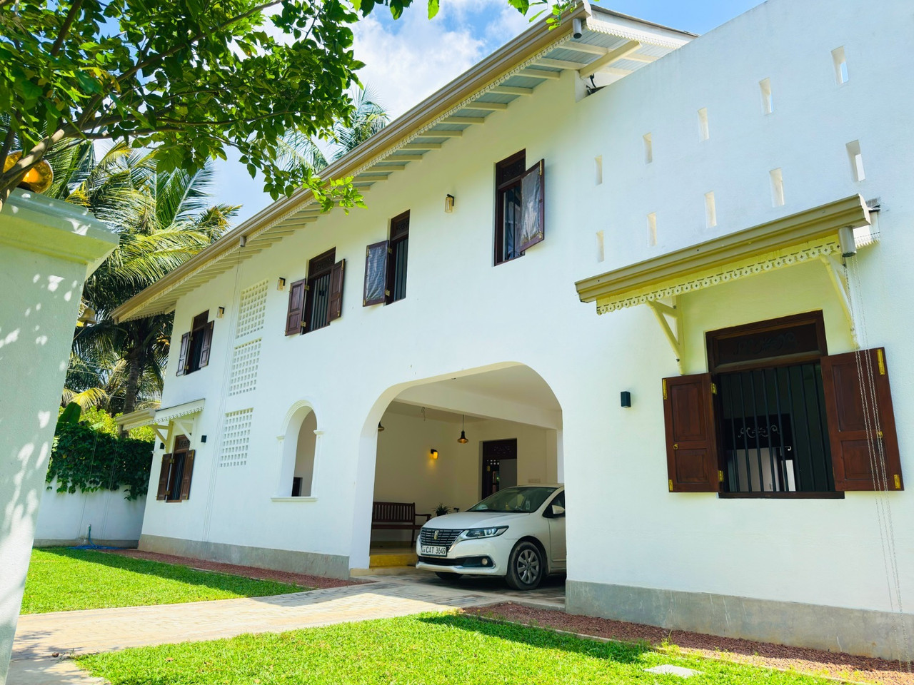 White colonial villa exterior with teak shutters