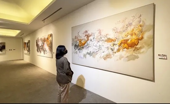 Pengunjung melihat lukisan di pameran seni rupa Retrospeksi KM60 yang berlangsung di Pasar Seni Ancol pada 17 Juli - 1Agustus 2022.