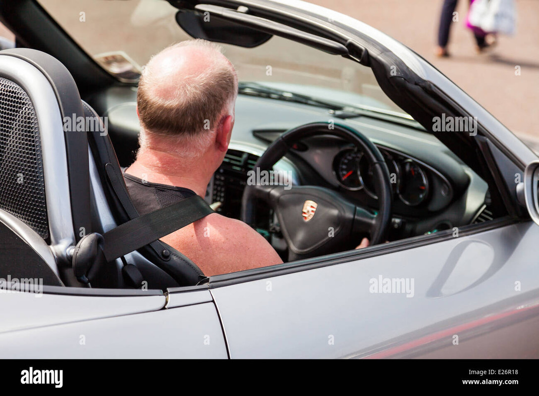 bald-man-driving-in-an-open-top-classic-porsche-car-on-a-warm-sunny-E26-R18.jpg