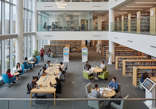 A large, modern university library full of students