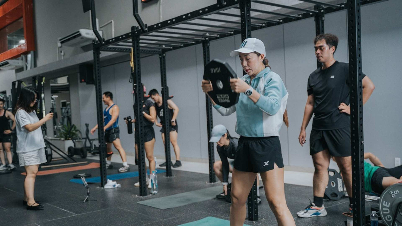 Hội viên nữ tập kháng lực với tạ đĩa 10kg trong buổi tập nhóm Fox Strength, áp dụng nguyên tắc tăng cơ bắp khoa học tại Active Fox TP.HCM