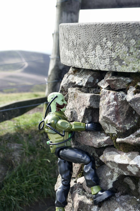 Green Robot climbing the stone marker post at Allermuir Hil. 43559725-28-A1-4-C14-A545-EE79745-A87-AE