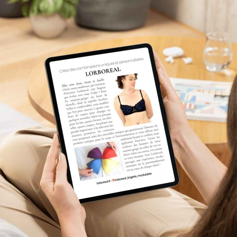 Mains tenant une tablette affichant l’article de Gala consacré à la marque française de lingerie modulable Lorboreal.