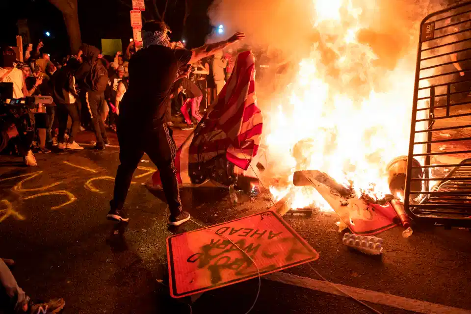 US flag thrown into a fire during protest near the White House on May 31 2020 in Washington DC.
