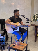 Ailton Souza tocando violão em evento intimista