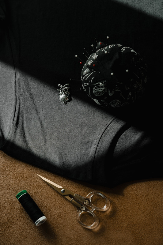 Scissors and thread on dark fabric