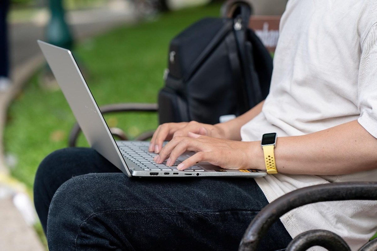 A person sitting on a bench using a computerDescription automatically generated A person sitting on a bench using a computerDescription automatically generated