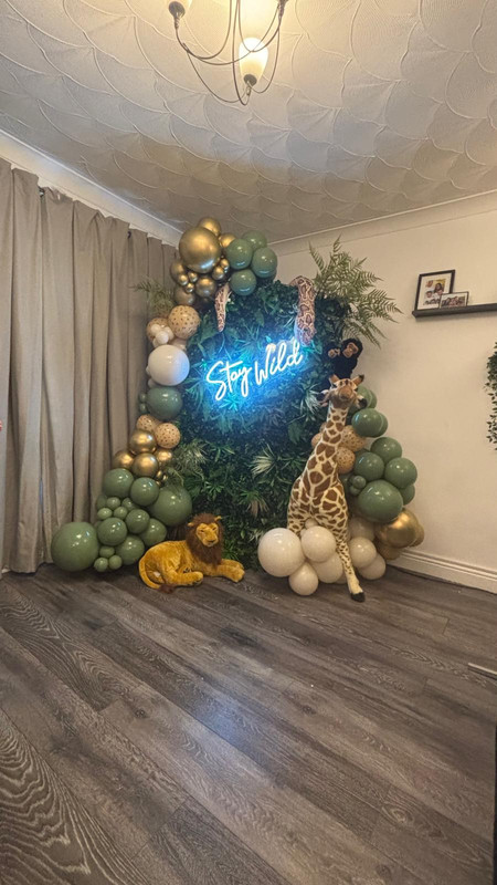 Balloon display with a neon light 'Stay Wild'
