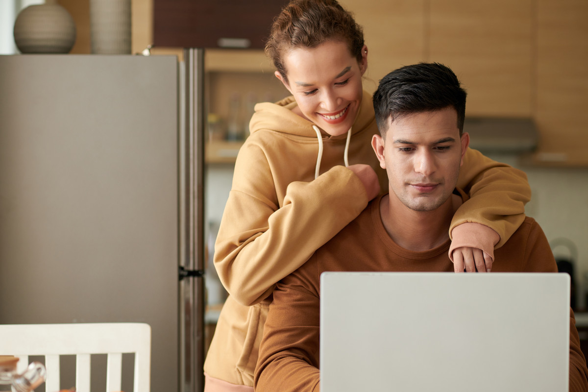 Couple using laptop at home