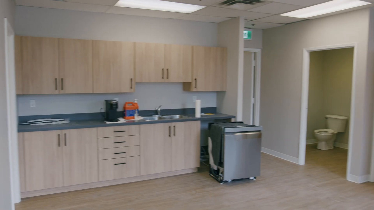 Finished kitchenette with new cabinets and a washroom beyond
