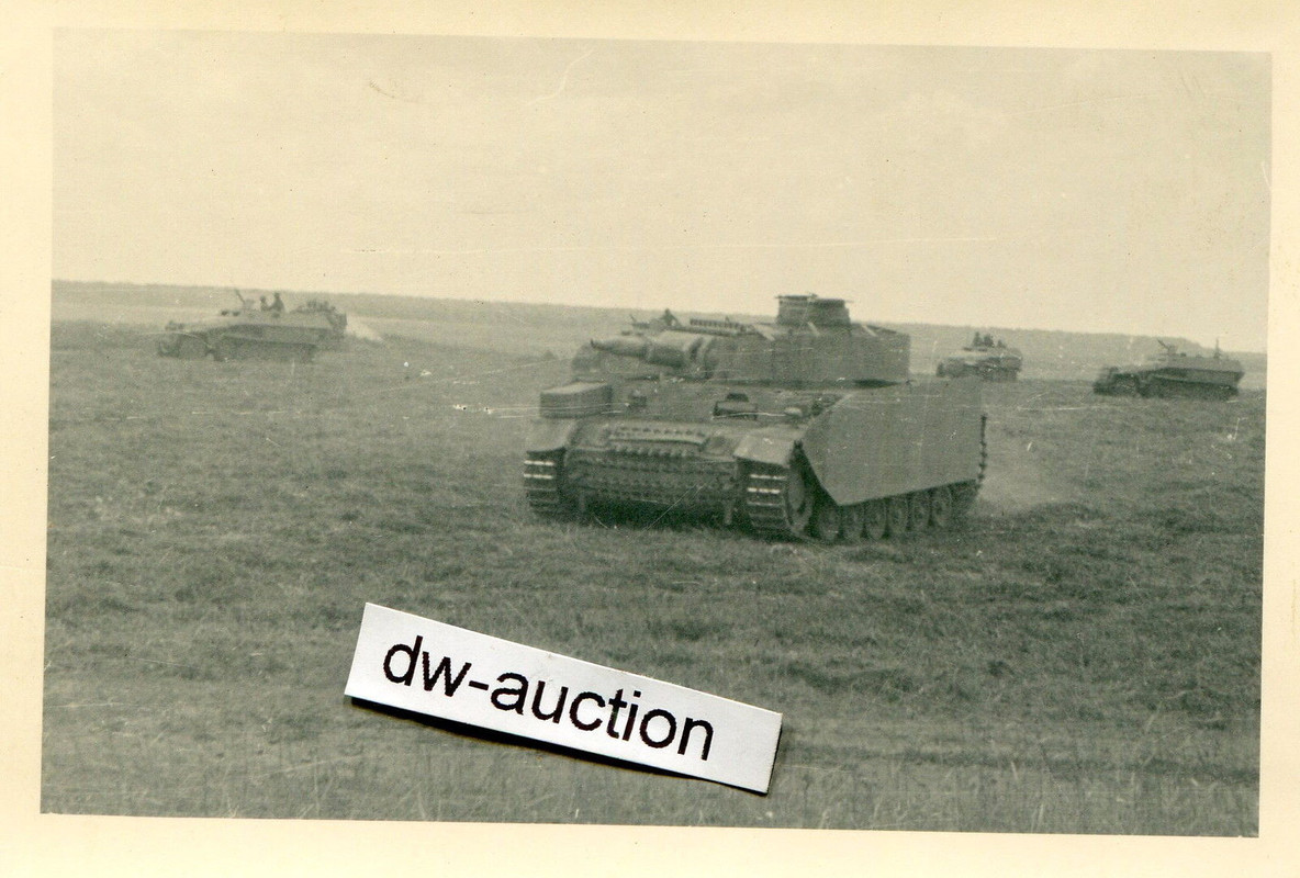 Panzer mit Seitenschürzen und SdKfz bei Angriff