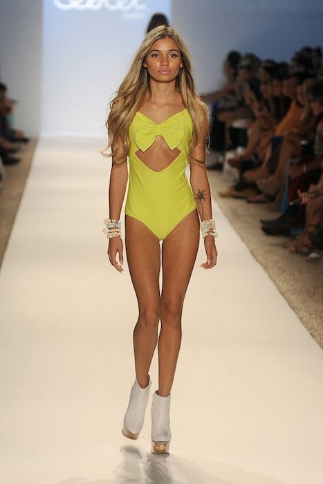 Med hendes mager krop og Lyseblond hårtype, uden BH (størrelse 32AA) på stranden i bikini
