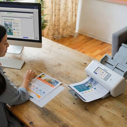 Scanner Brother ADS-4700W em ambiente de escritório moderno, destacando seu design compacto.