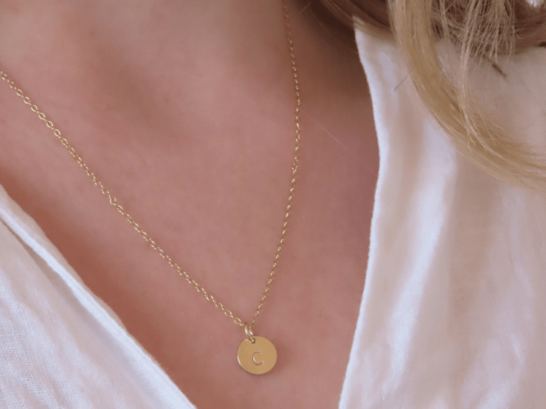 This dainty and personalizable disk necklace is the perfect way to show off your personality. Crafted from 925 sterling silver and 18k gold plated, this necklace is sure to turn heads wherever you go. The initial of your choice will be hand stamped onto the disk, making it a totally unique piece of jewelry that you can wear with pride. Whether you choose your own initial or a special memento of someone close to you, this necklace is a wonderful way to express who you are. Perfect for everyday wear, it will add a touch of elegance to any outfit. Add this beautiful and personalized piece of jewelry to your collection today!