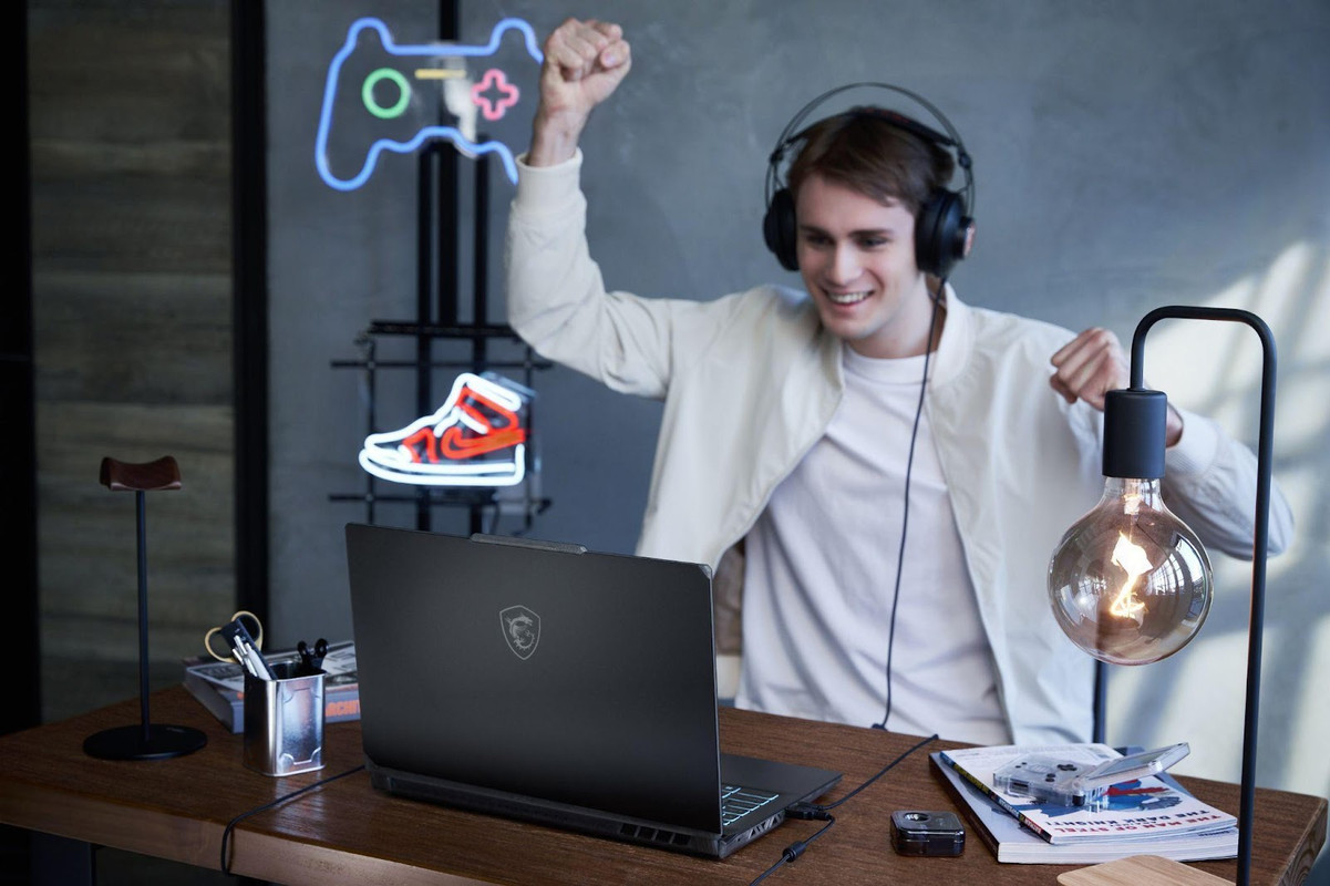 A person wearing headphones and holding his hands up in front of a computerDescription automatically generated A person wearing headphones and holding his hands up in front of a computerDescription automatically generated