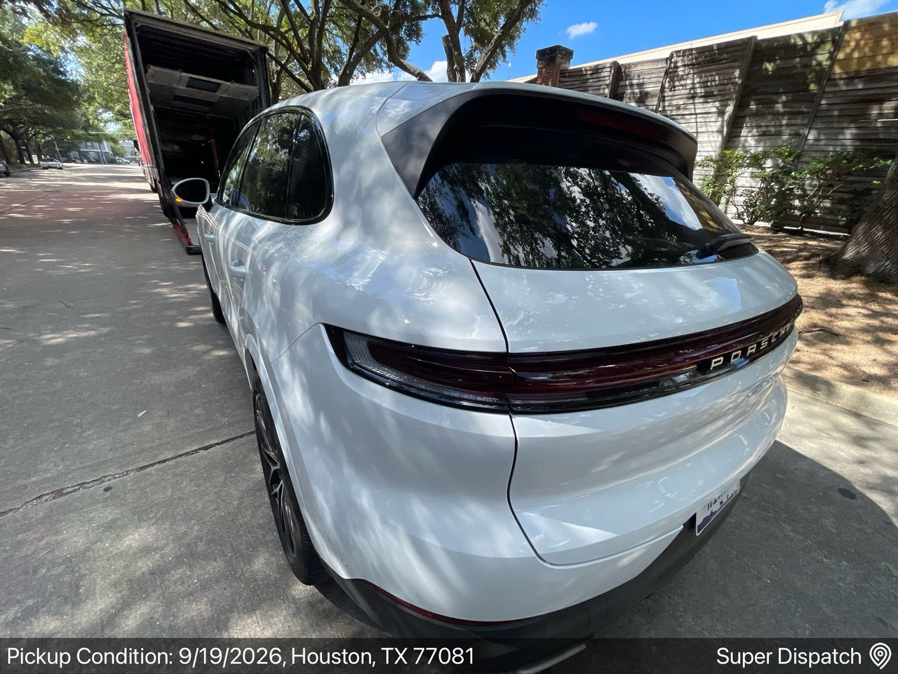 White Porsche SUV at an enclosed auto transport pickup in Houston, Texas
