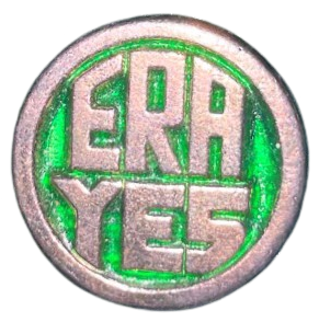 a metal enamel pin that is mostly silver and says 'ERA YES' on it, with the background behind the text being a bright green