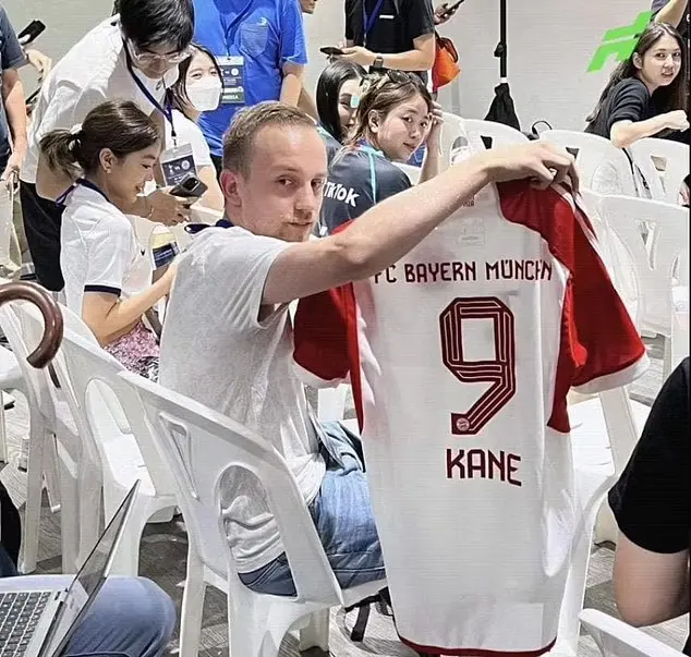 Journalist Max Schrader showing a Kane's shirt of Bayern