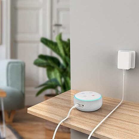 Un Echo Dot de Amazon conectado con un cable de alimentación largo, destacando la conveniencia del cable extralargo.