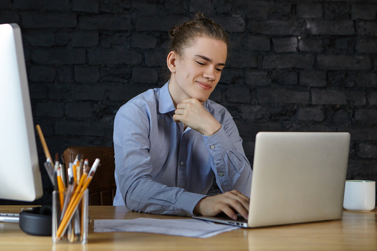 young office worker having five minutes break messaging online via social networks using laptop his