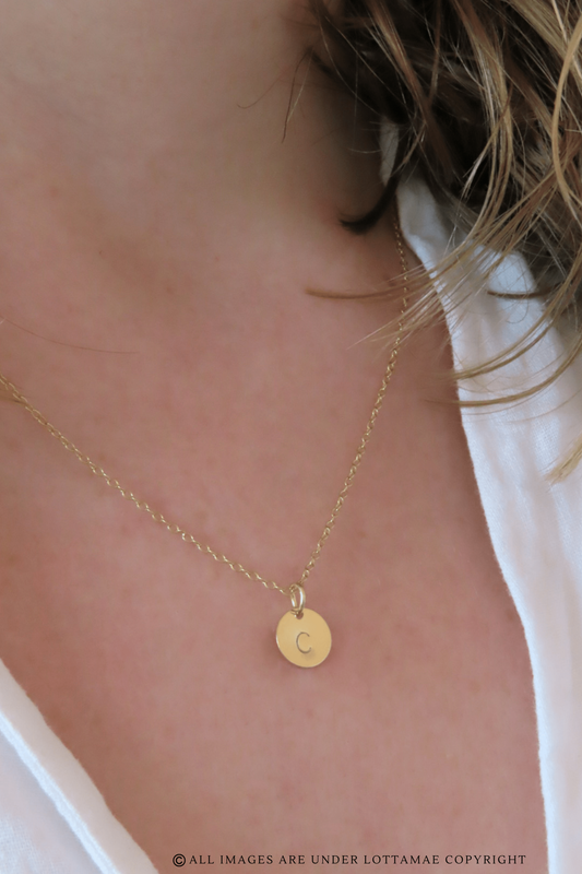 This dainty and personalizable disk necklace is the perfect way to show off your personality. Crafted from 925 sterling silver and 18k gold plated, this necklace is sure to turn heads wherever you go. The initial of your choice will be hand stamped onto the disk, making it a totally unique piece of jewelry that you can wear with pride. Whether you choose your own initial or a special memento of someone close to you, this necklace is a wonderful way to express who you are. Perfect for everyday wear, it will add a touch of elegance to any outfit. Add this beautiful and personalized piece of jewelry to your collection today!