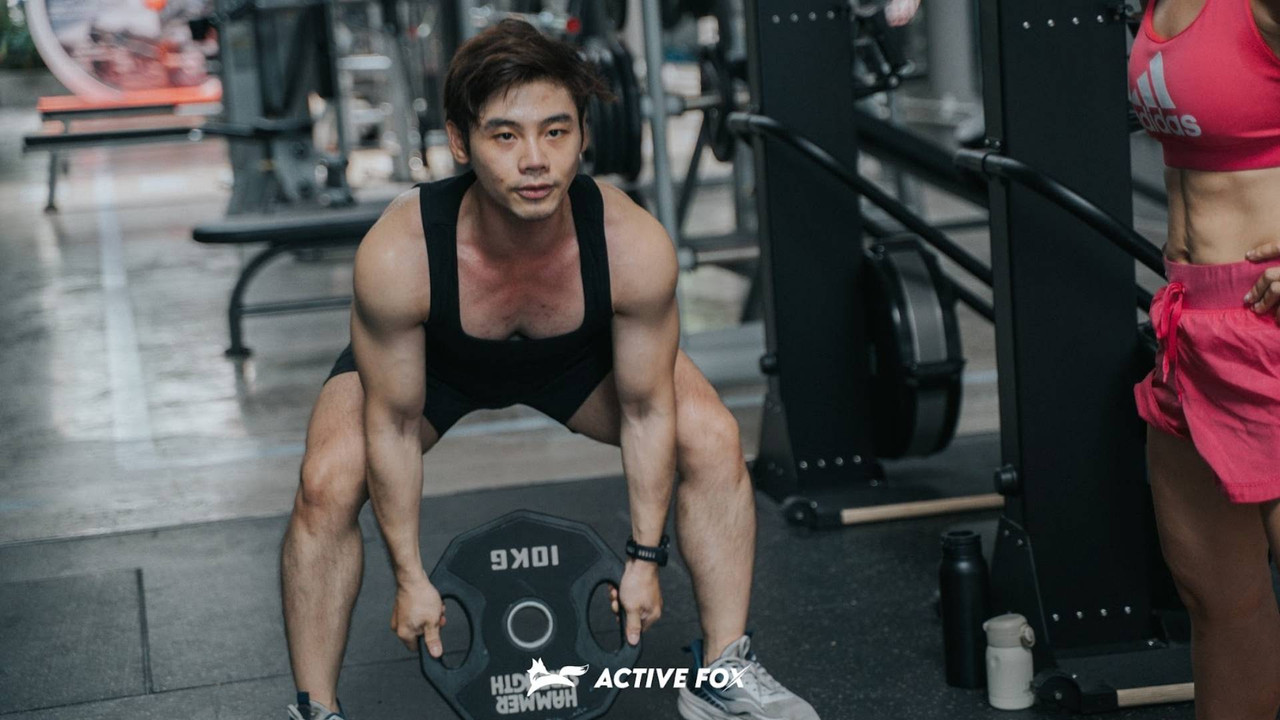 Nam hội viên Active Fox tập kéo tạ đĩa 10kg với cơ bắp phát triển, minh họa cơ chế tăng cơ bắp qua tập kháng lực tại phòng gym TP.HCM