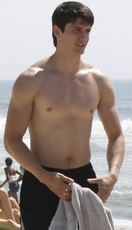 Med skjorteløs athletisk kropp på stranda
