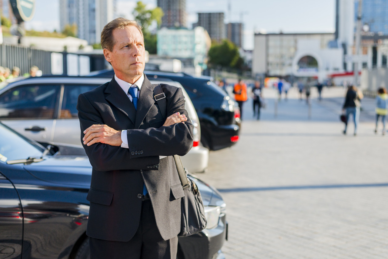 matured businessman with crossed arms standing street