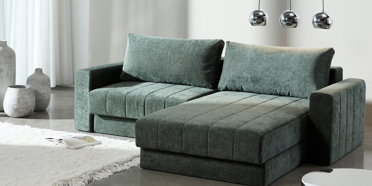 Akello Lounger Innovation Living — canapé d'angle compact avec méridienne, coutures channel, tissu vert forêt — Déco Éléments Paris 18e