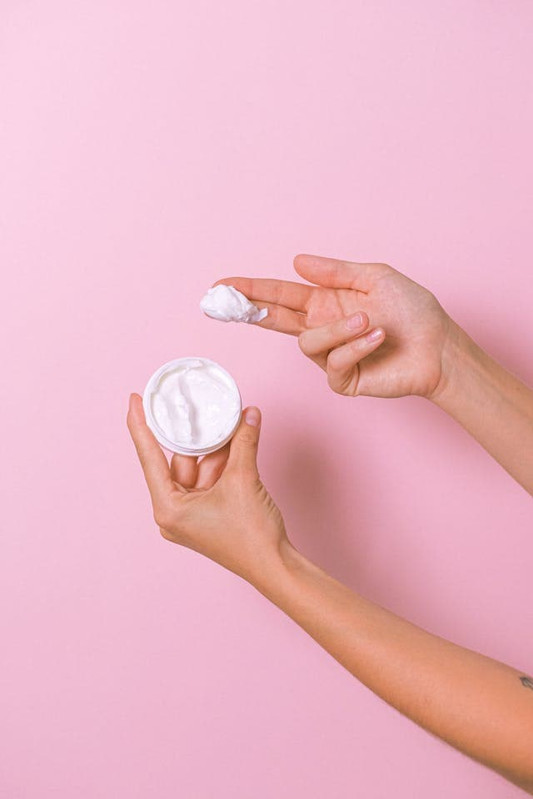 a woman's hands holding moisturizer, emphasizing to use moisturizer for healthy skin 