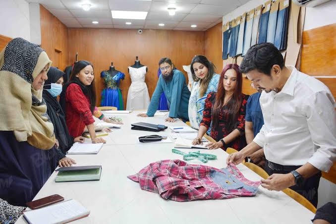 Fashion designers reviewing sketches and quality checks in the studio