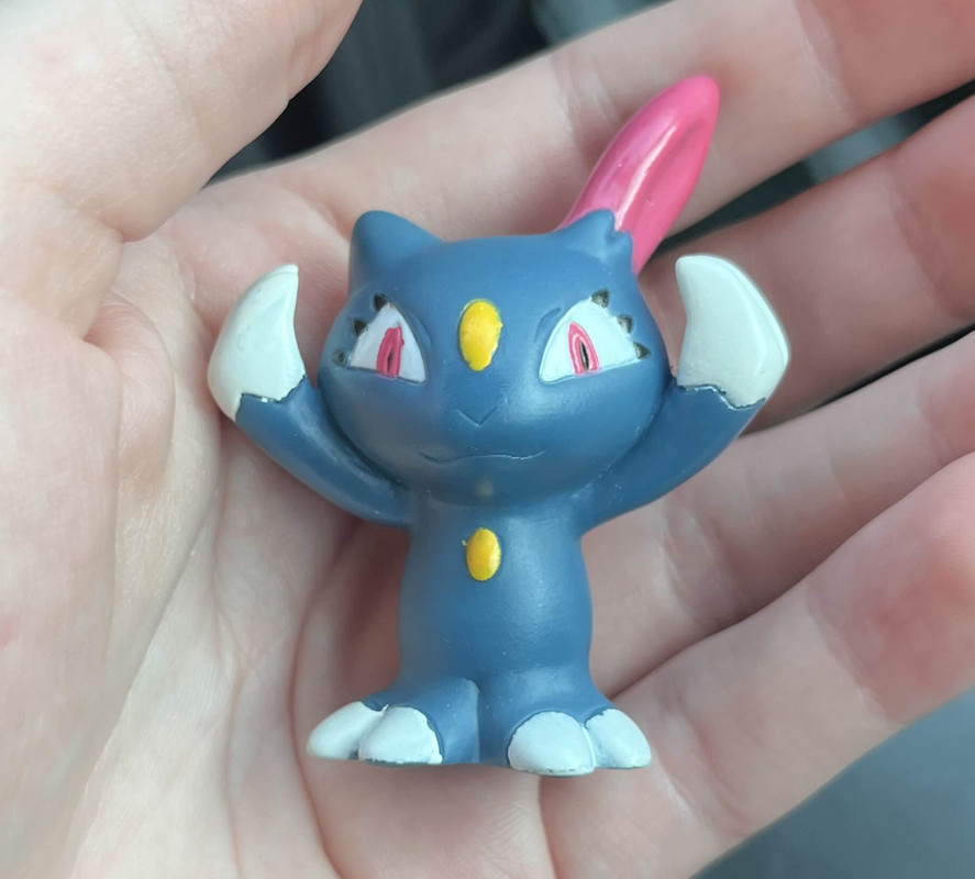 Tiny plastic figurine of the fictional creature Sneasel from pokemon