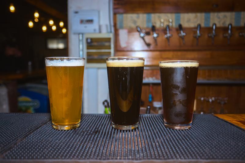 Tres vasos de cerveza artesanal de Cervecería Rural sobre la barra