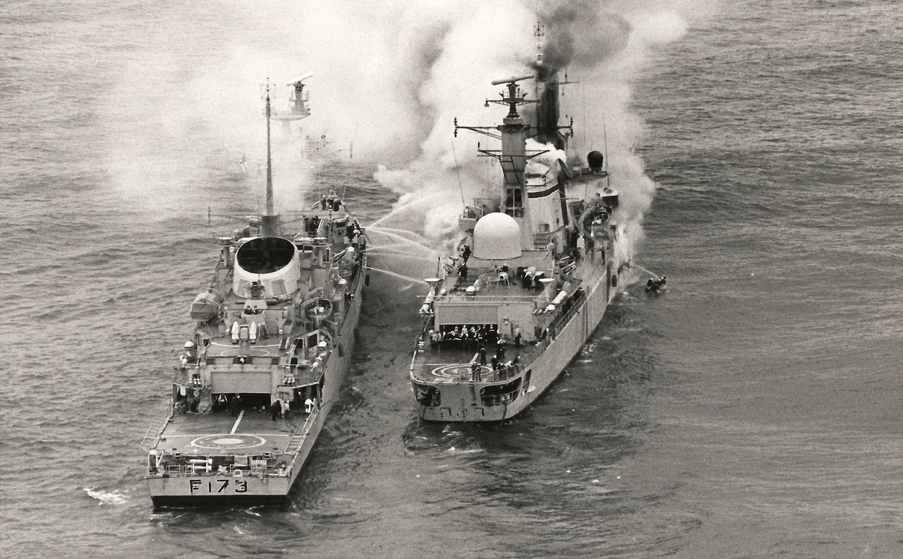 HMS Sheffield (D.80) получает помощь от фрегата Arrow