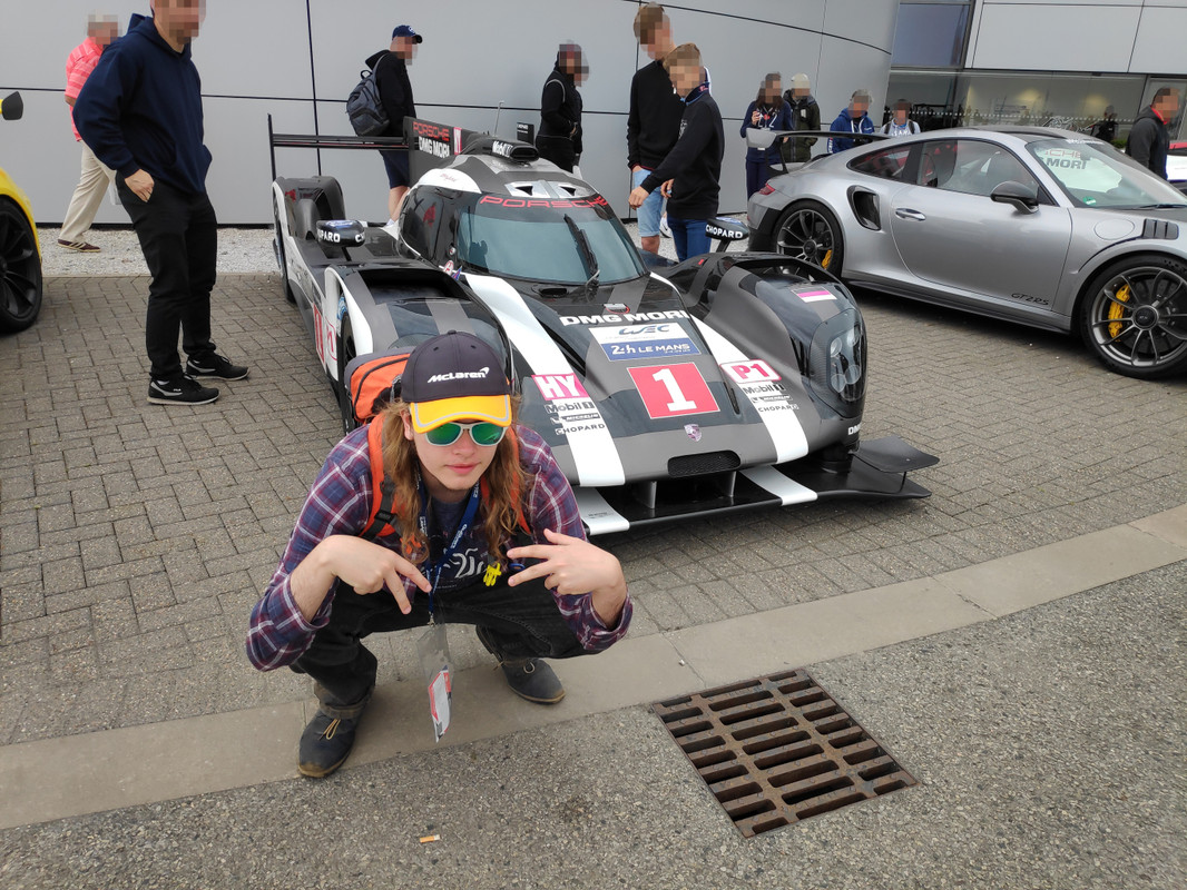 Chris posing in front of a Porsche LMP1 car