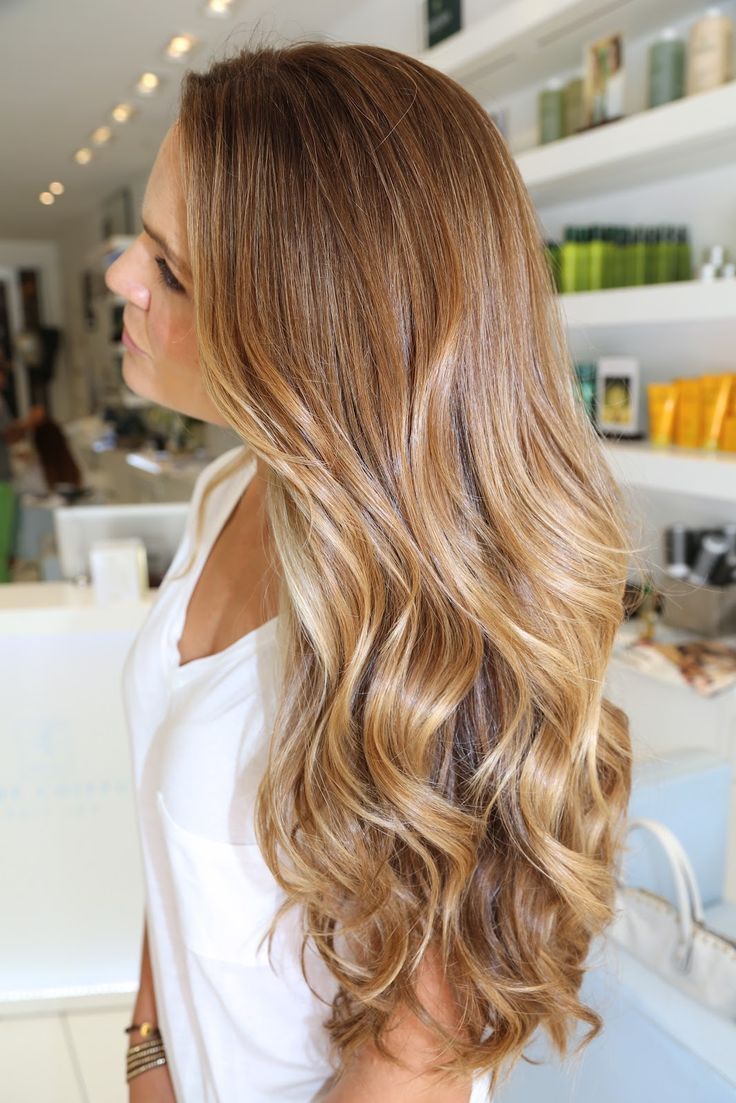 Brown-haired woman with long wavy hair dyed caramel blonde