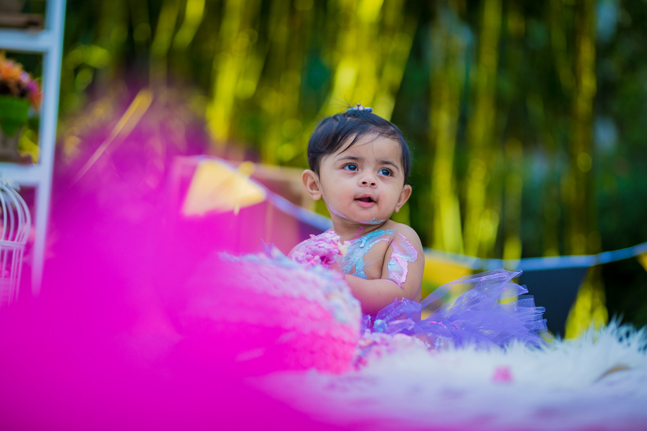 Cake smash photography Leicester — South Indian baby enjoying first birthday cake