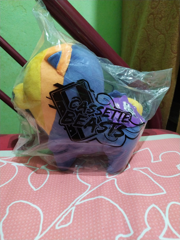 Official Cassette Beasts Pombom plushie wrapped in a plastic bag